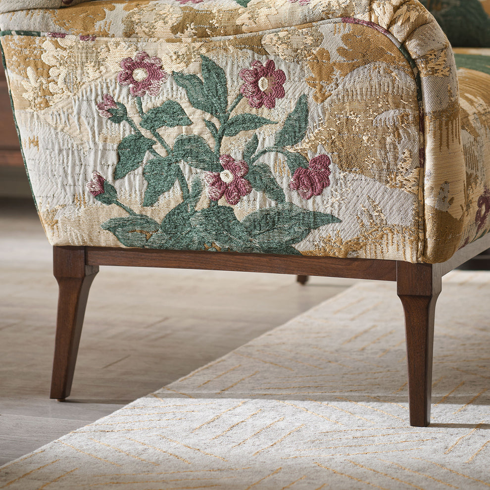 Line Dance Stickley wool rug in oatmeal with copper lines under a floral armchair.