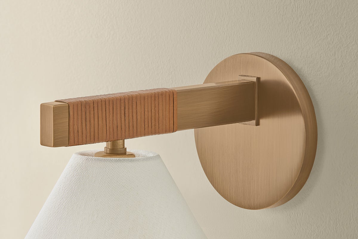 Stonely wall sconce with patina brass frame, jute wrap detail, and white linen shade.