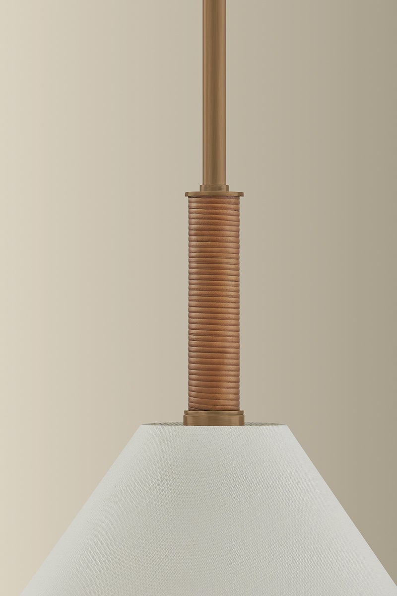 Stoney Pendant featuring a white linen shade and a patina brass stem wrapped in natural jute.