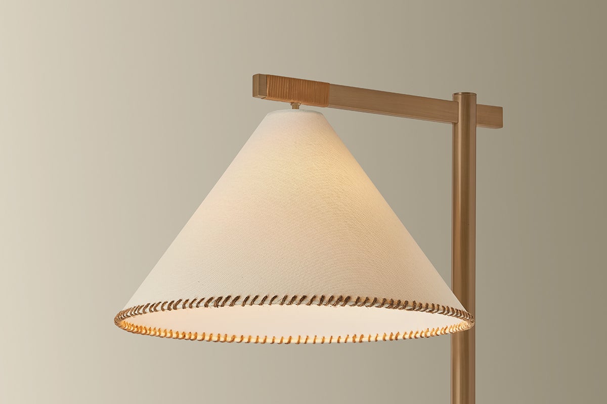 Stoney floor lamp with white linen shade, whip-stitch edge, and brass frame with jute wrap.