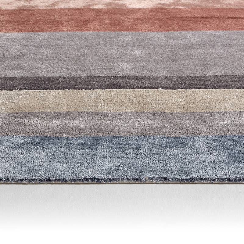 Syntax hand-tufted wool and viscose rug with modern horizontal stripes in blue, grey, beige, and terracotta.