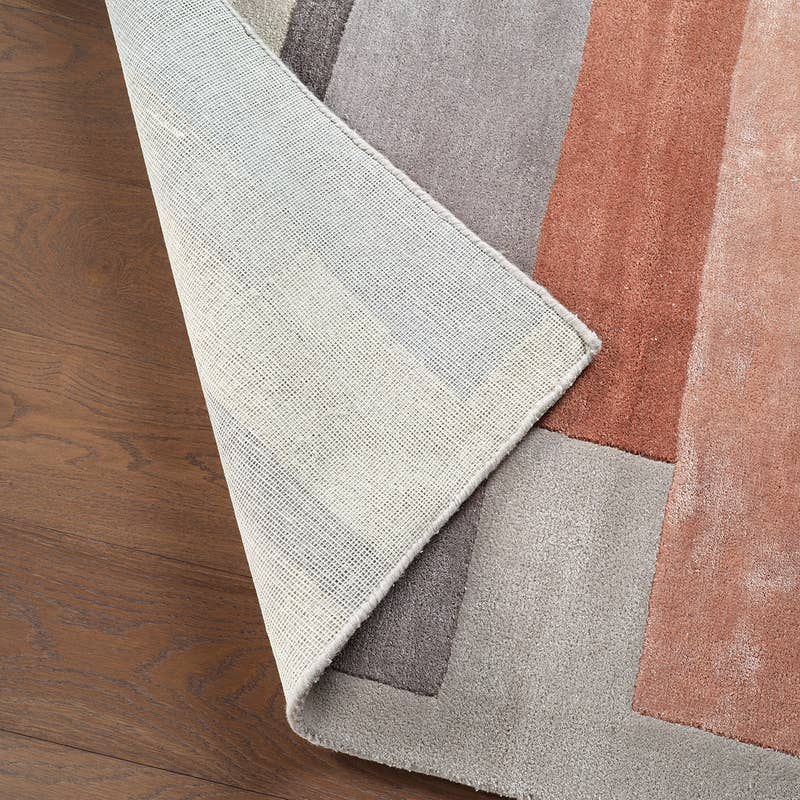 Syntax hand-tufted wool and viscose rug in grey and terracotta, showing the woven backing.