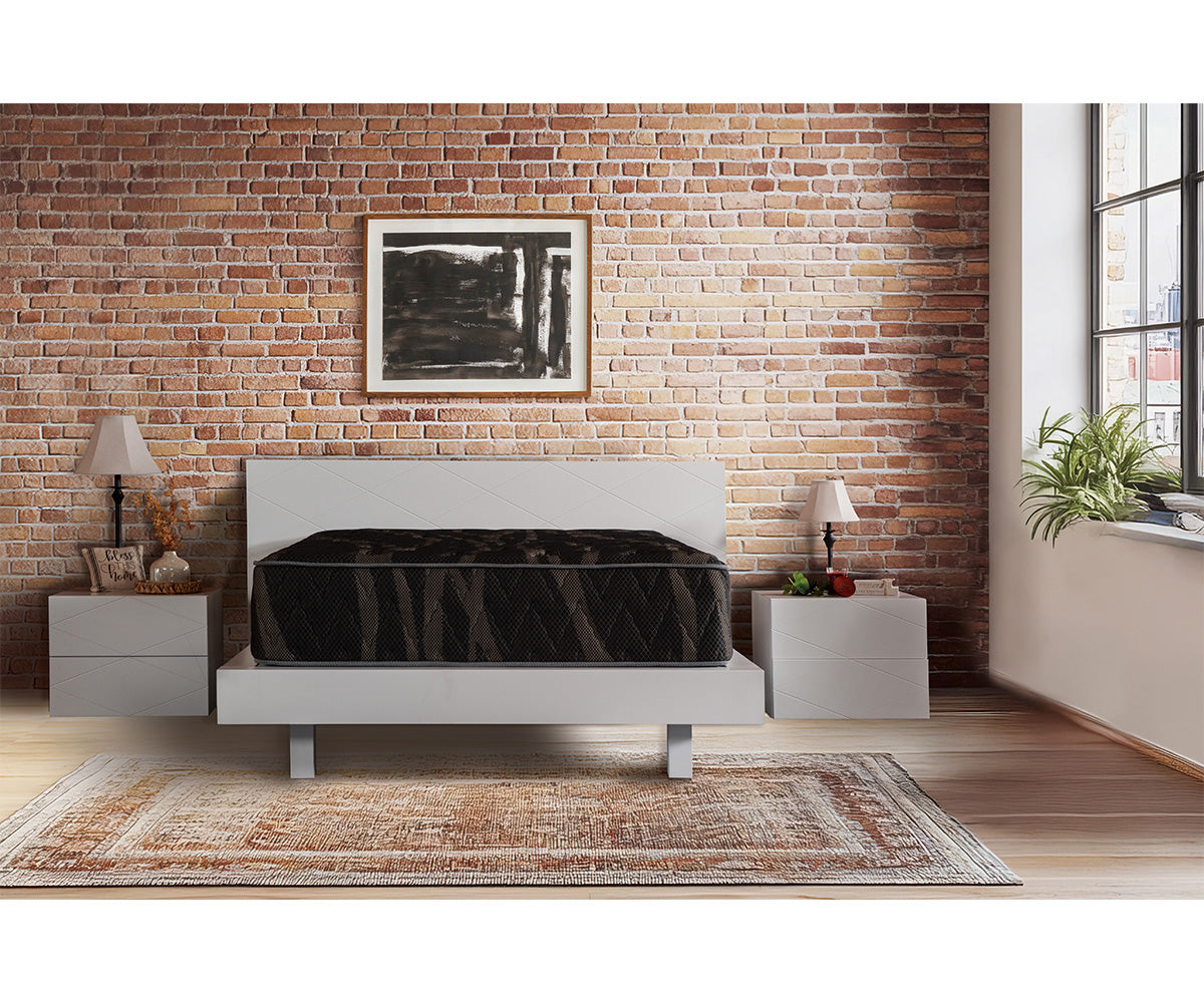 Lumina medium-firm mattress on a white bed frame in a brick-walled bedroom.