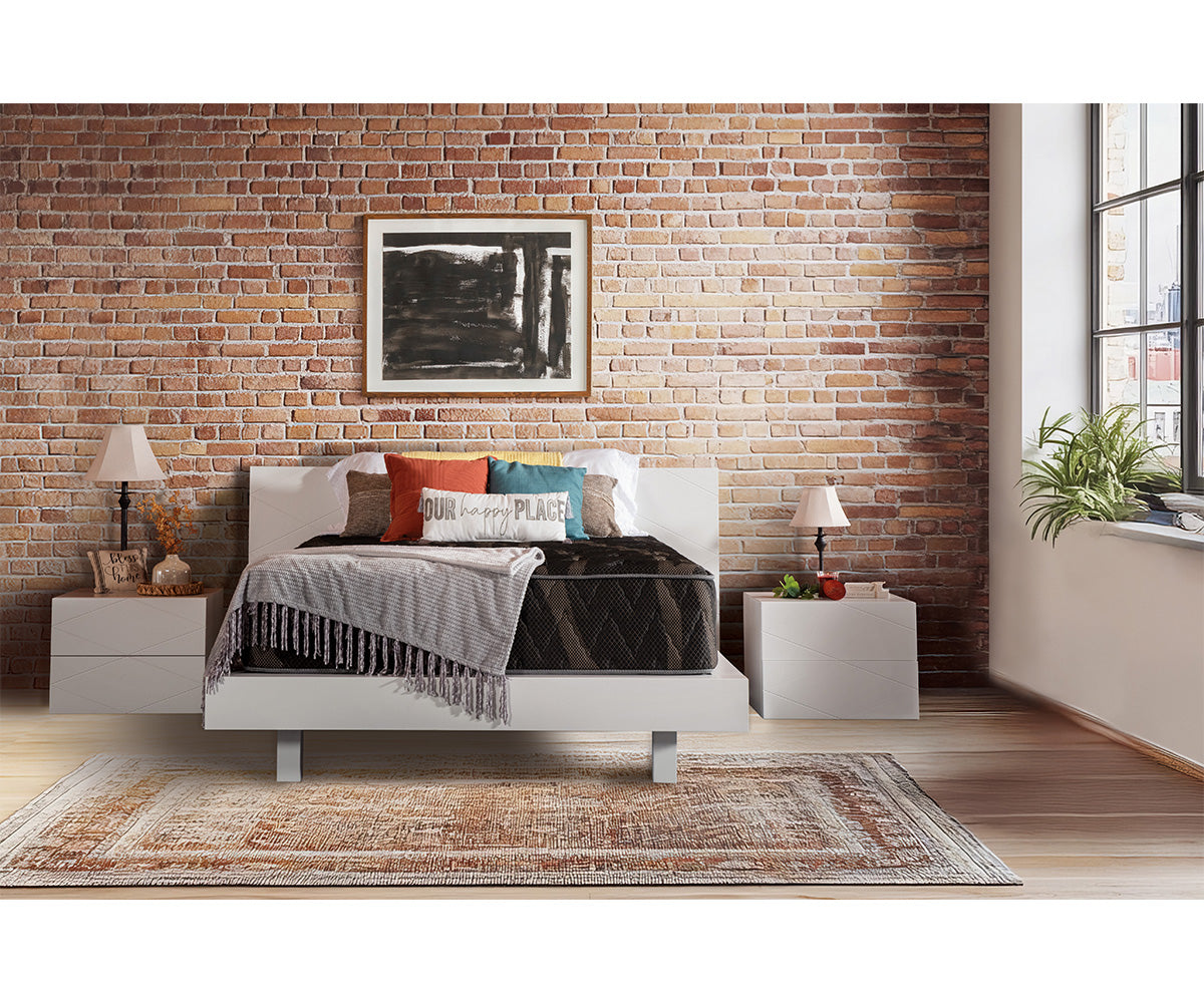 Lumina medium-firm mattress on a white bed frame in a brick-walled bedroom.