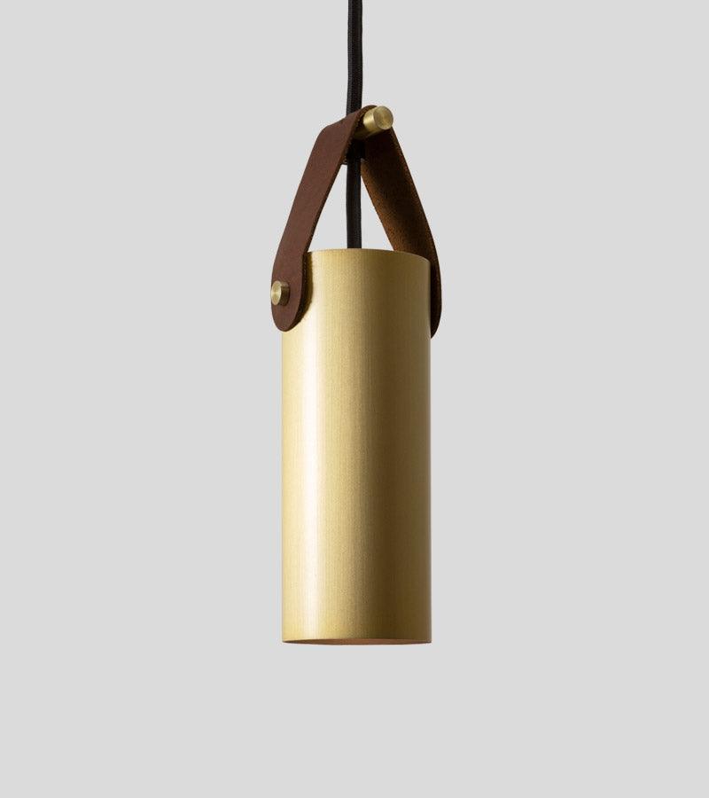 Spero brass cylinder pendant light with a brown leather strap hanger.