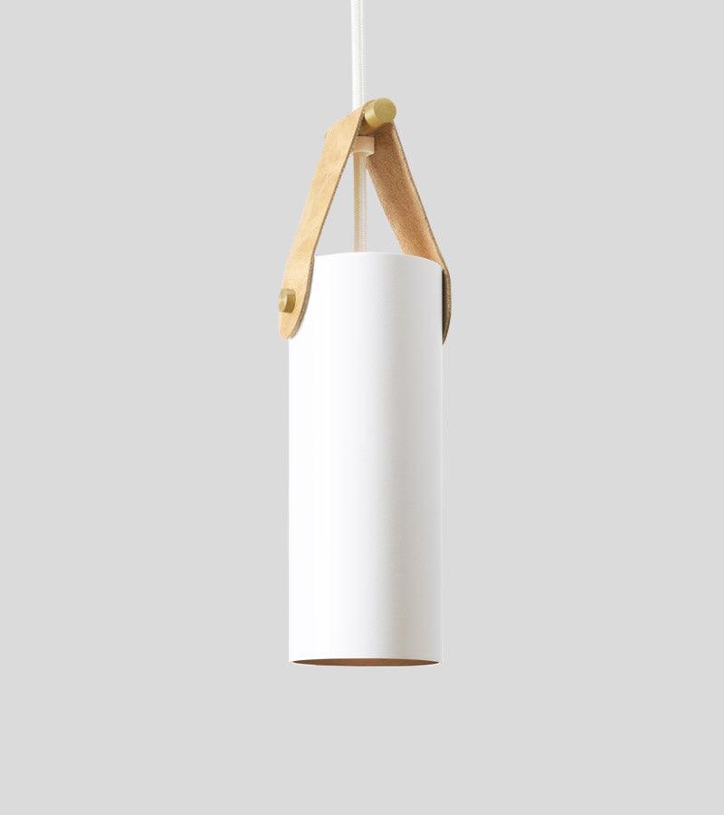 Spero white cylinder pendant light with a tan leather strap and brass hardware.