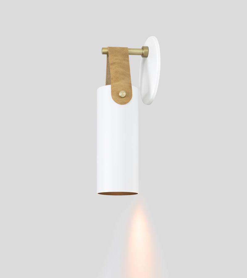 Spero minimalist white cylinder wall sconce with brass and tan leather accents.