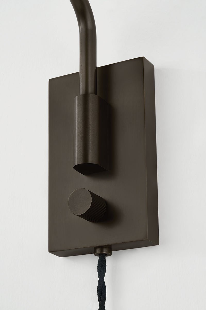Dark bronze rectangular backplate of the Yvette plug-in sconce with a ribbed dimmer knob and black cord.