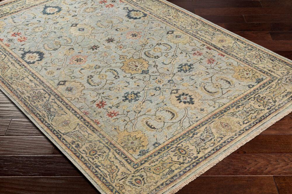 Anatolia hand-knotted wool rug with traditional floral patterns in muted blue, beige, and gold.