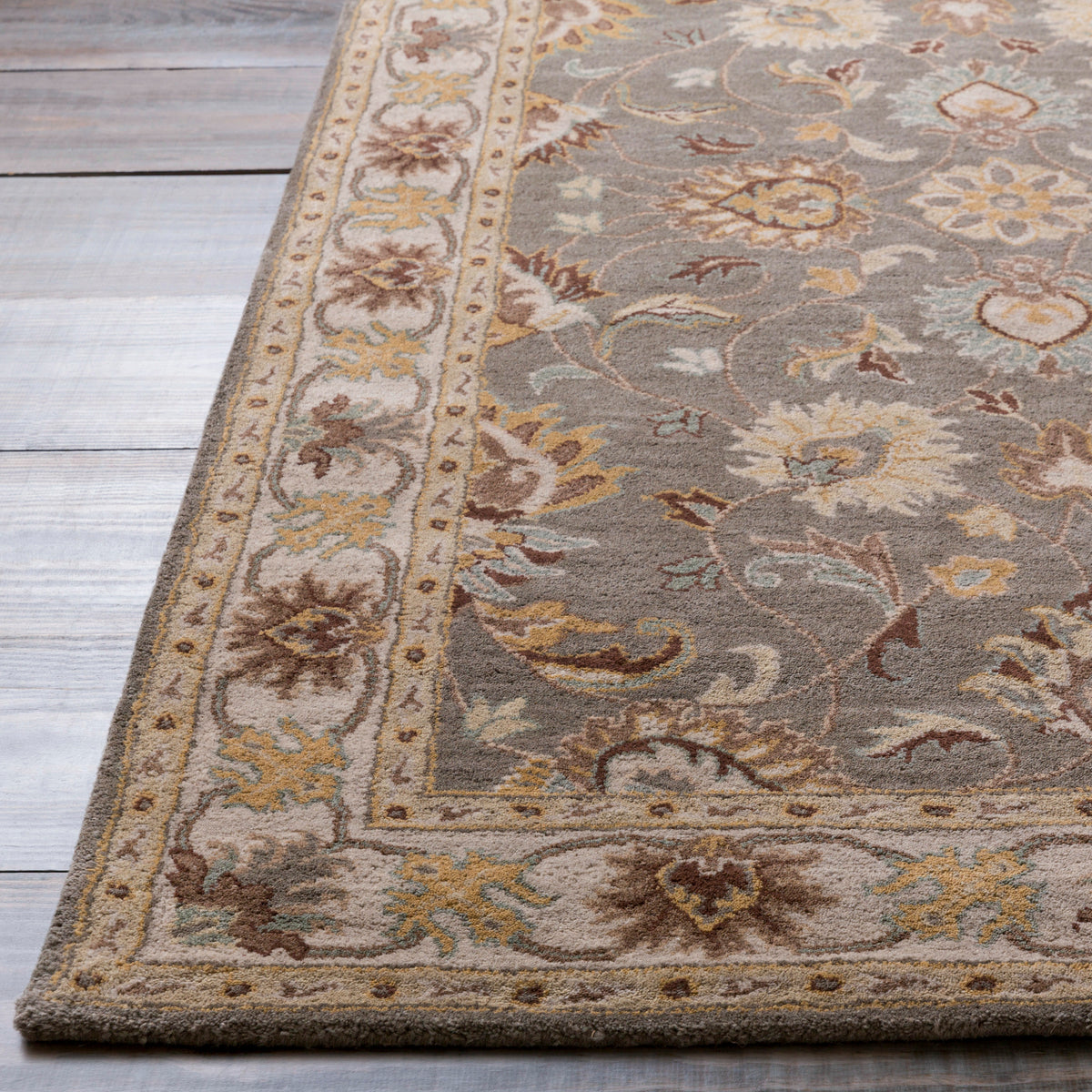 Nobility Flint hand-tufted wool rug with charcoal field and mustard floral patterns on wood floor