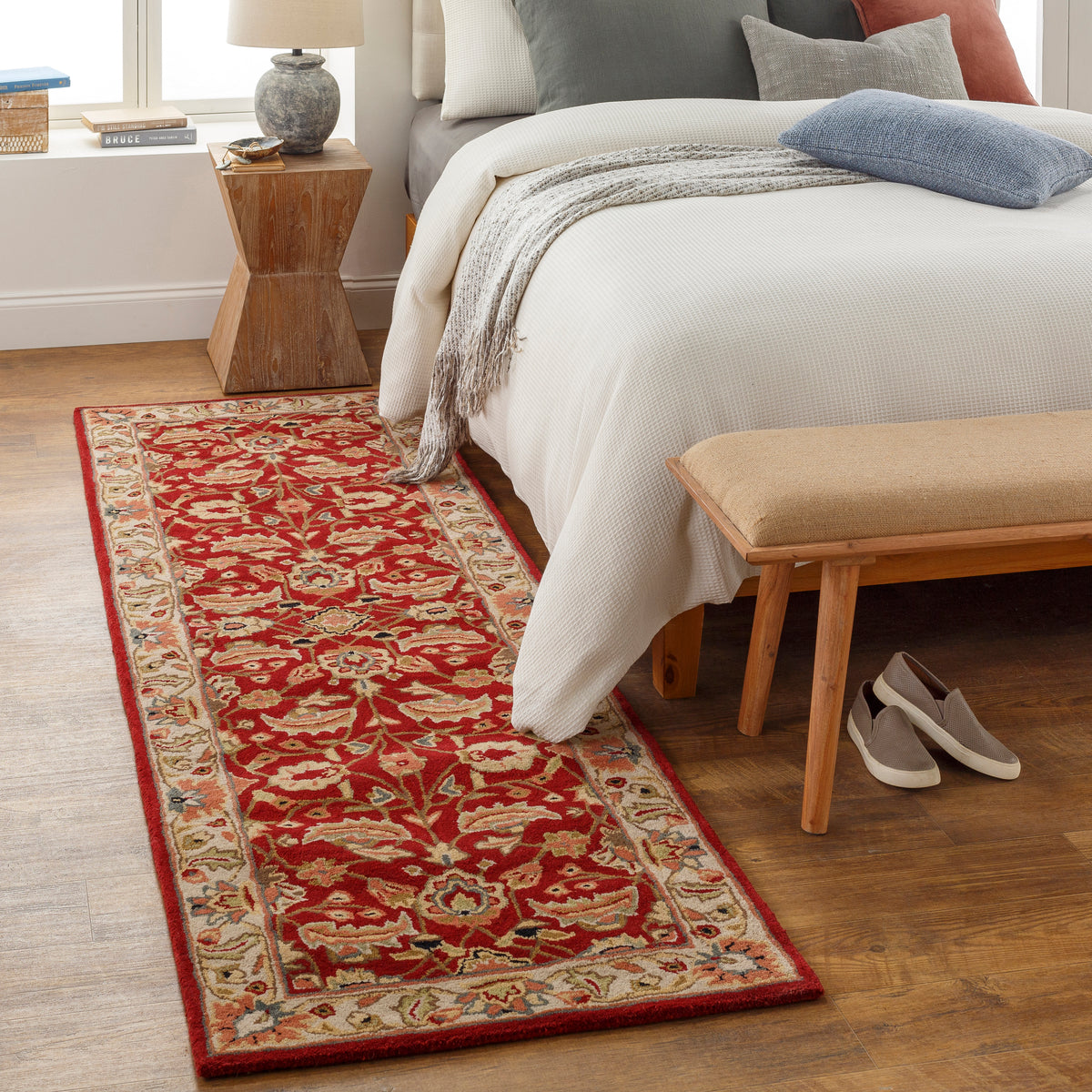Lucia Cinnamon hand-tufted wool runner rug with a red floral pattern next to a bed