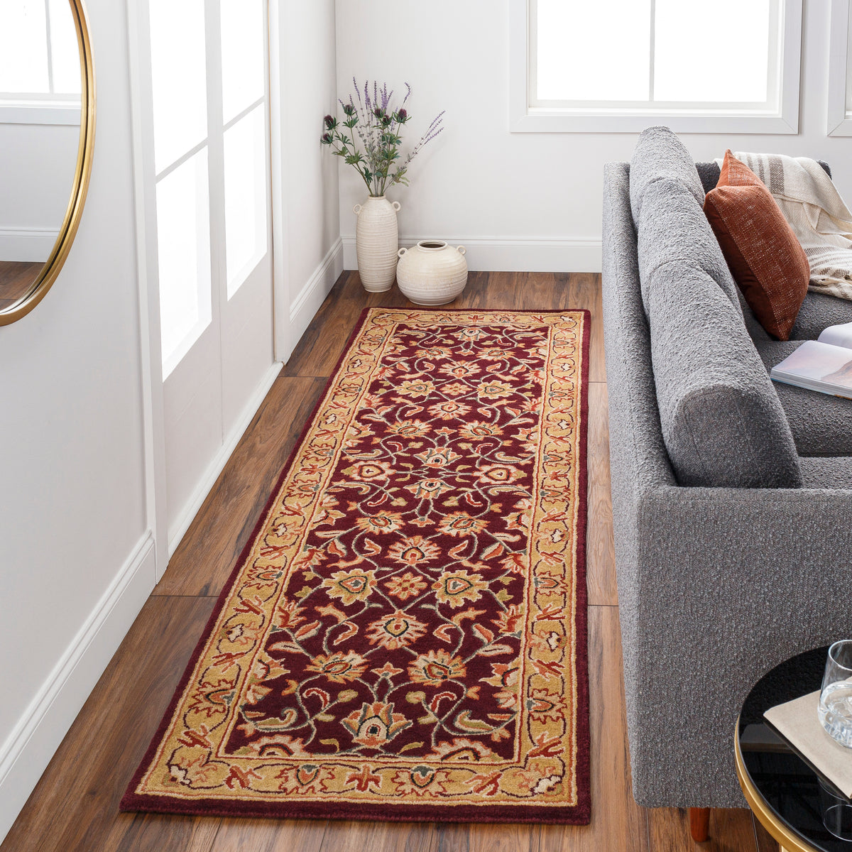 Nobility Amethyst burgundy hand-tufted wool runner rug with tan floral patterns in a living room.