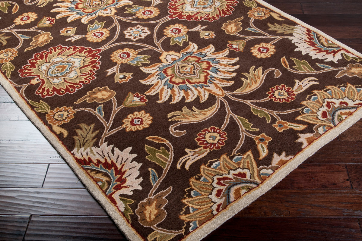 Mediterranean Umber hand-tufted wool rug with floral patterns on dark wood floors.