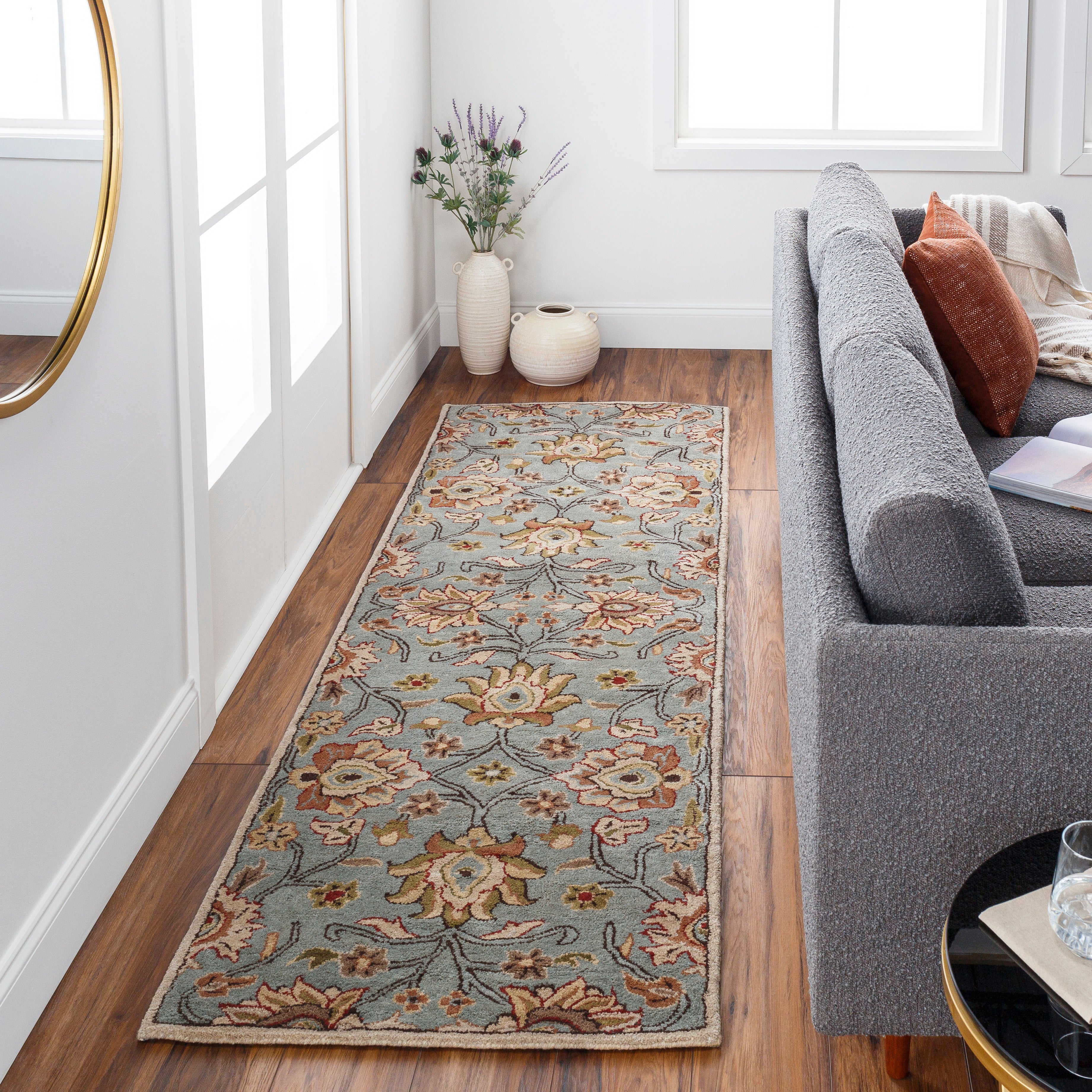 Mediterranean Cerulean hand-tufted wool runner rug with a floral pattern on hardwood floor
