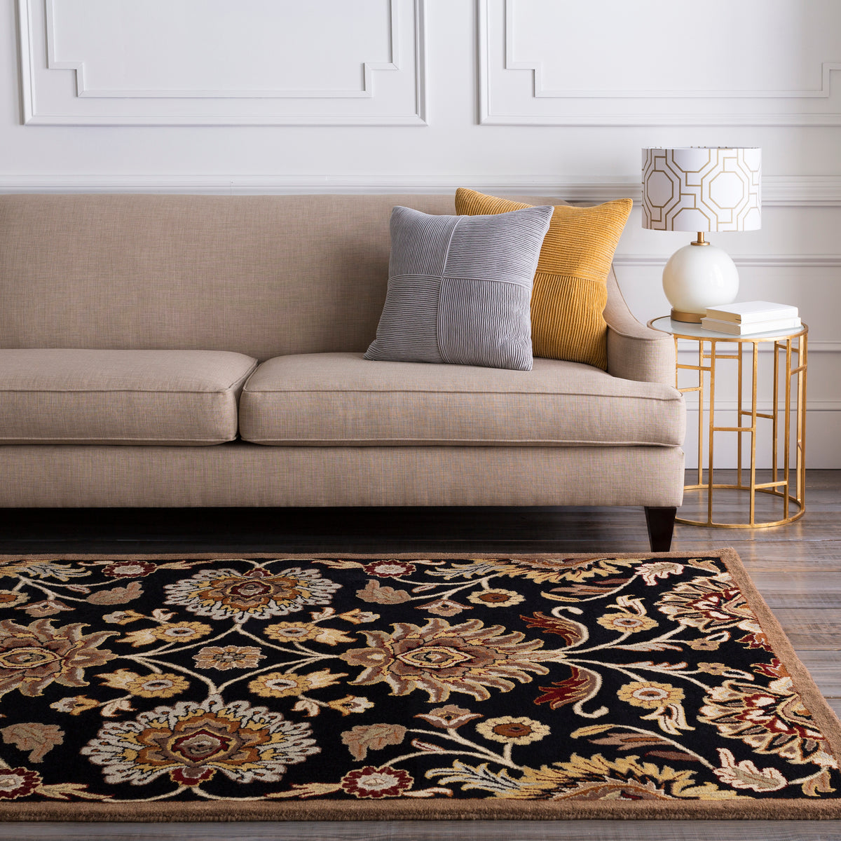 Mediterranean Ink hand-tufted wool rug with black background and floral pattern under a beige sofa.