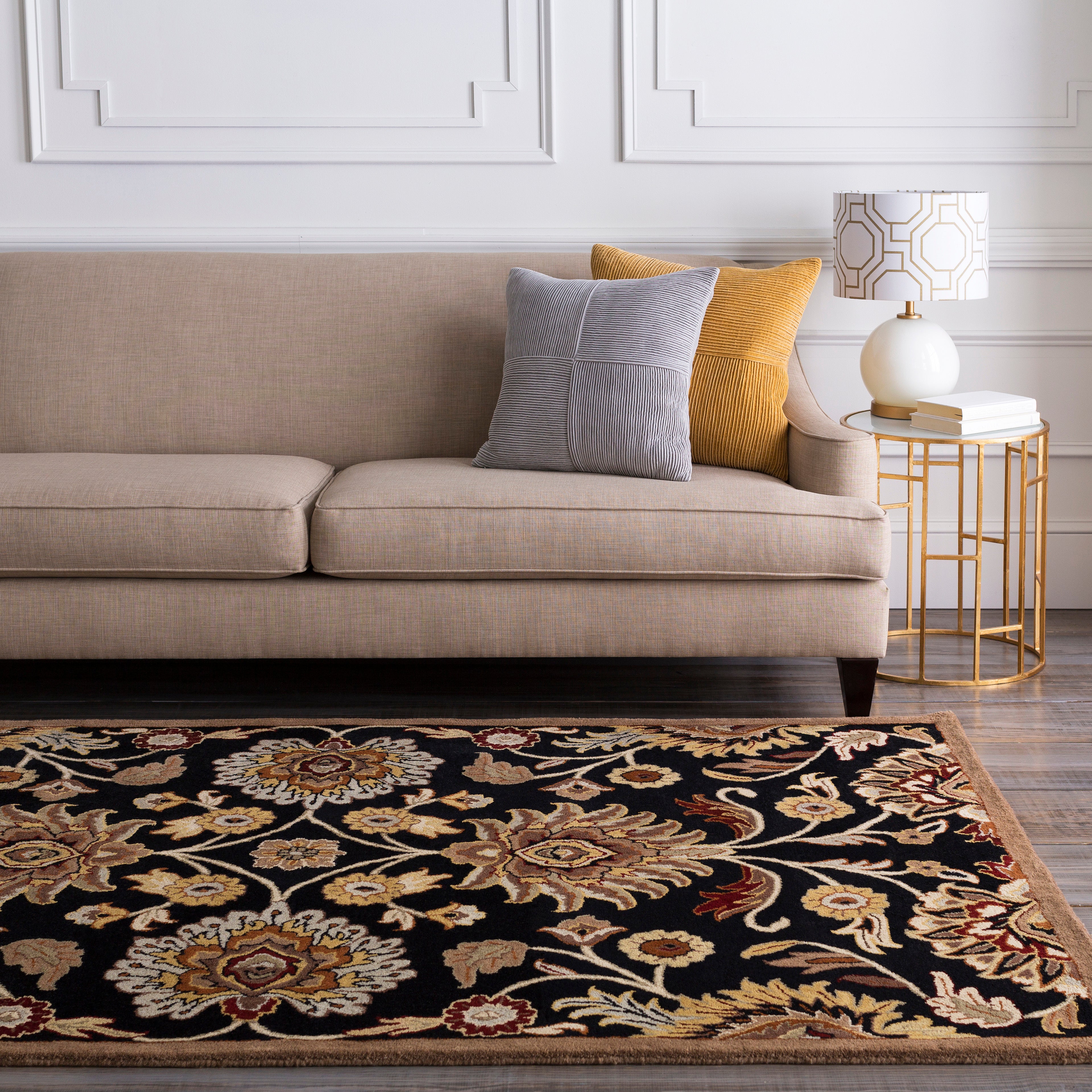 Mediterranean Ink hand-tufted wool rug with black background and floral pattern under a beige sofa.