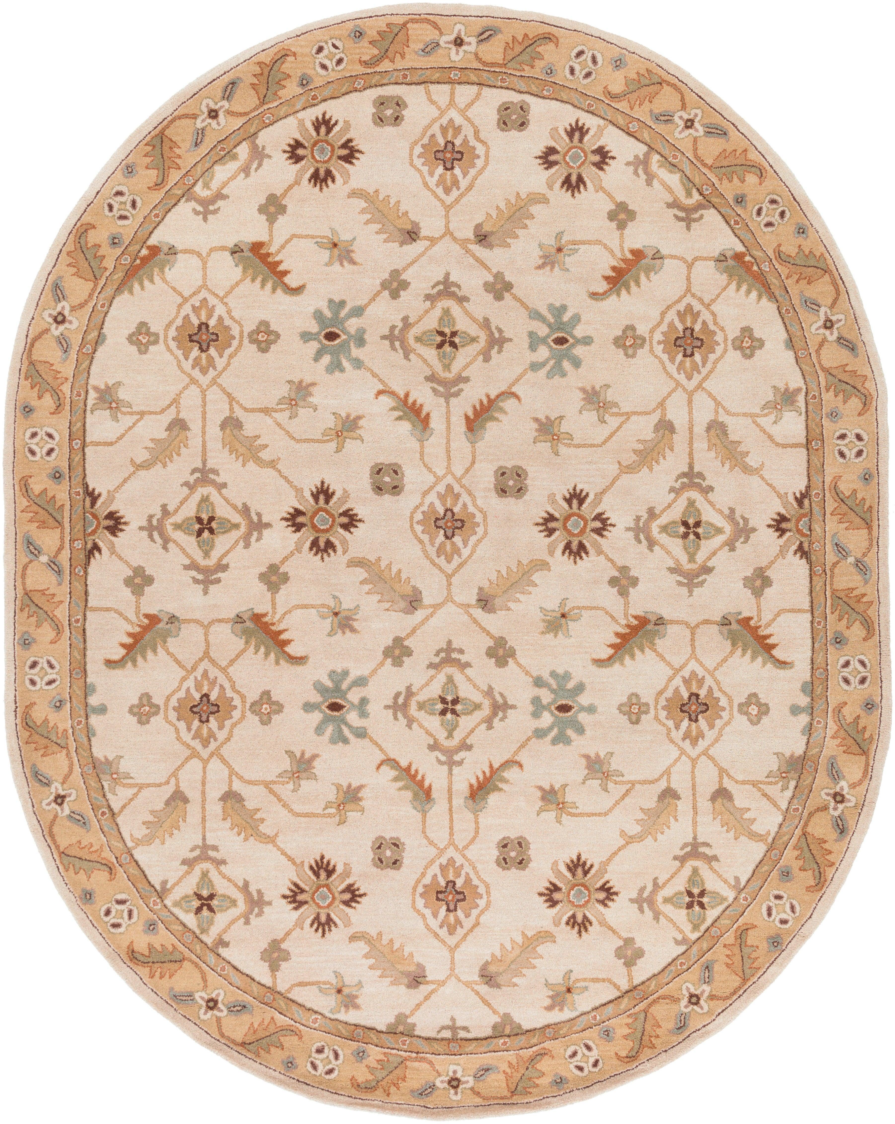 Oval Carthage Beige hand-tufted wool rug with traditional floral patterns and borders.