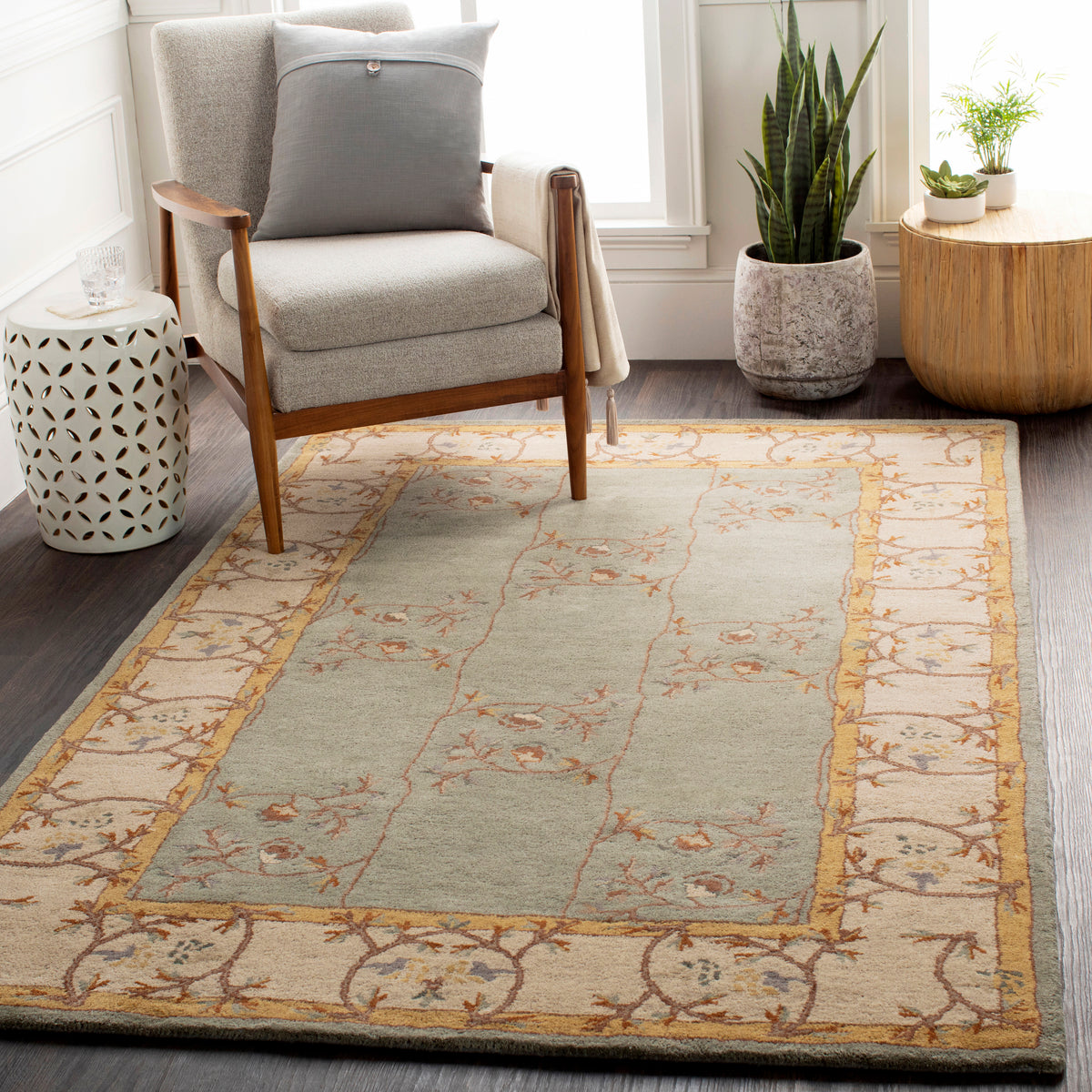 Corinth Azure hand-tufted wool rug with light blue and beige floral pattern in a living room.