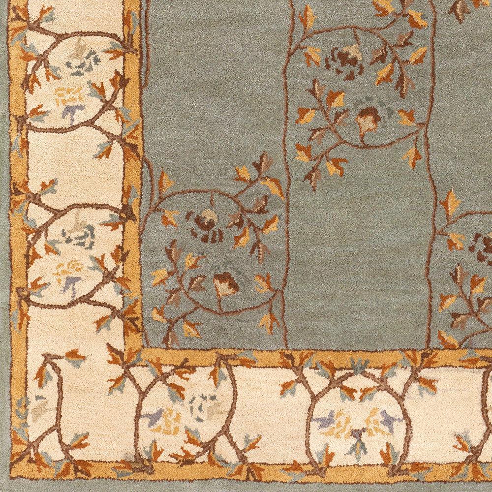 Corinth Azure hand-tufted wool rug with light blue backdrop and floral border.