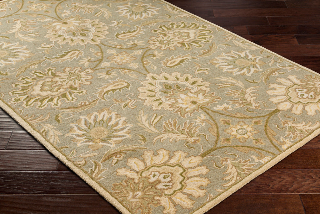 Mediterranean Sky hand-tufted wool rug with sage, ivory, and olive floral patterns on dark wood floor.