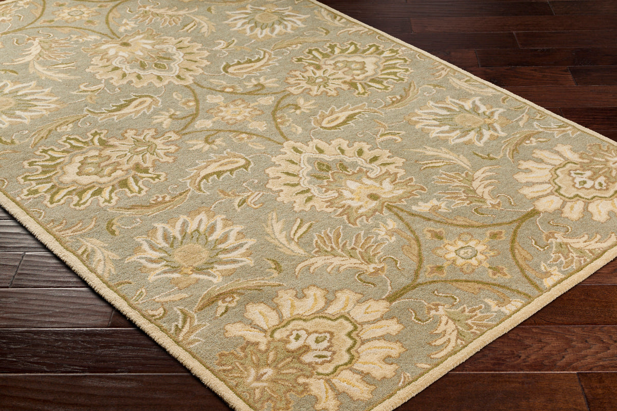 Mediterranean Sky hand-tufted wool rug with sage, ivory, and olive floral patterns on dark wood floor.