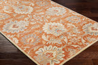 Mediterranean Cider hand-tufted wool rug with burnt orange floral patterns on dark wood floor