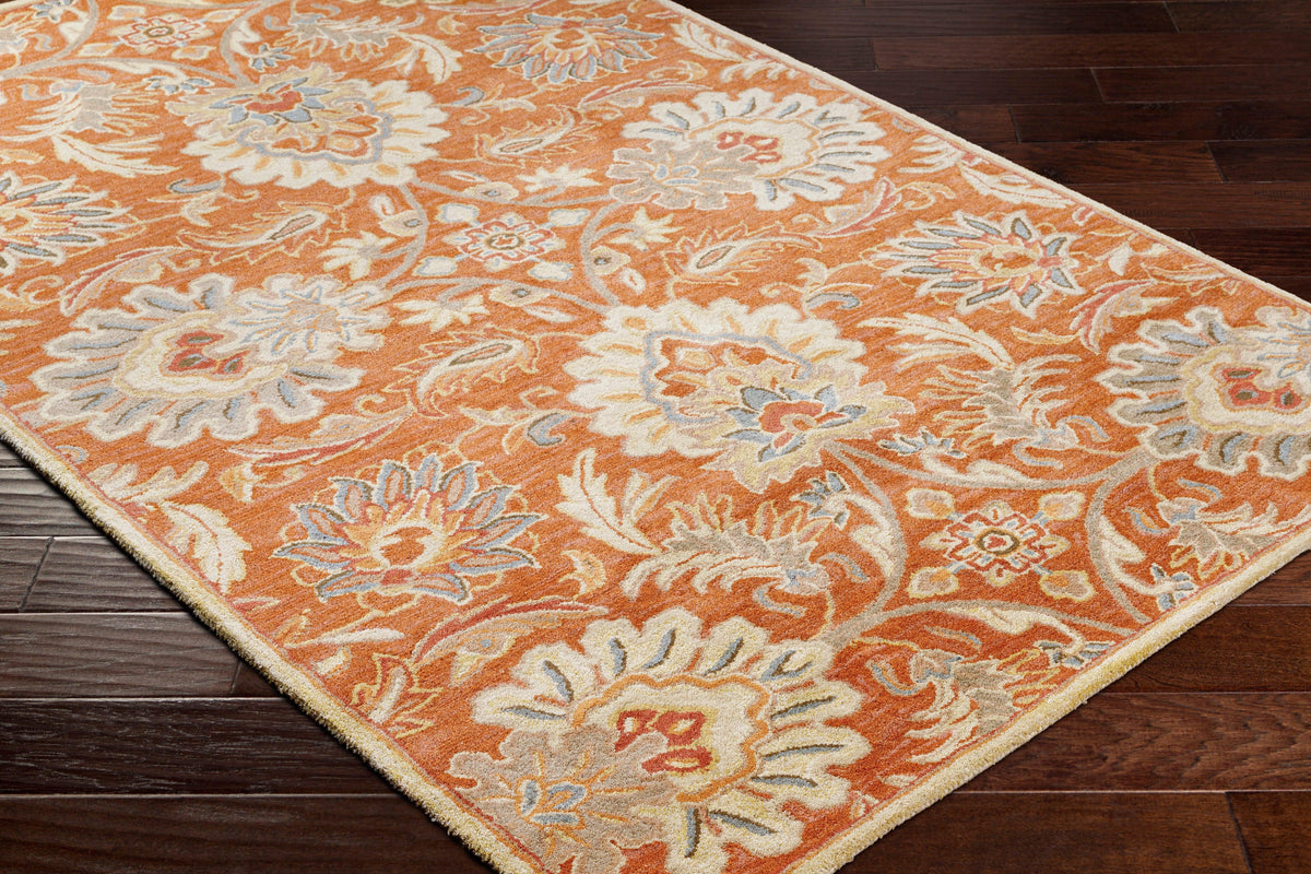 Mediterranean Cider hand-tufted wool rug with burnt orange floral patterns on dark wood floor