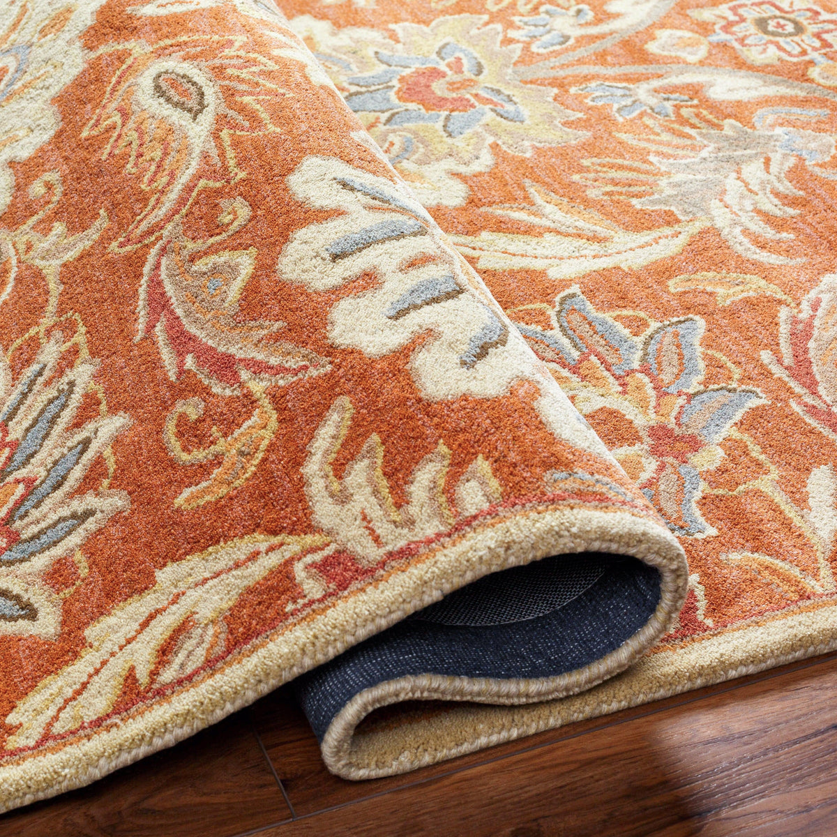 Mediterranean Cider hand-tufted wool rug with burnt orange floral patterns and rolled corner