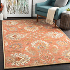 Mediterranean Cider hand-tufted wool rug with burnt orange floral patterns in a living room.