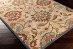 Mediterranean multi hand-tufted wool rug with floral patterns on dark wood floor.