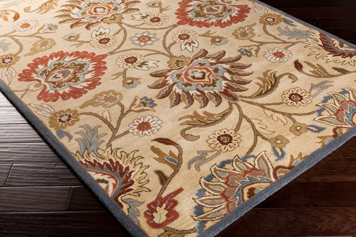 Mediterranean multi hand-tufted wool rug with floral patterns on dark wood floor.