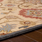Mediterranean hand-tufted wool rug with red and blue floral patterns on tan background