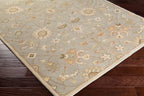 Giardino Stone blue-grey hand-tufted wool rug with a floral pattern on dark wood floors.