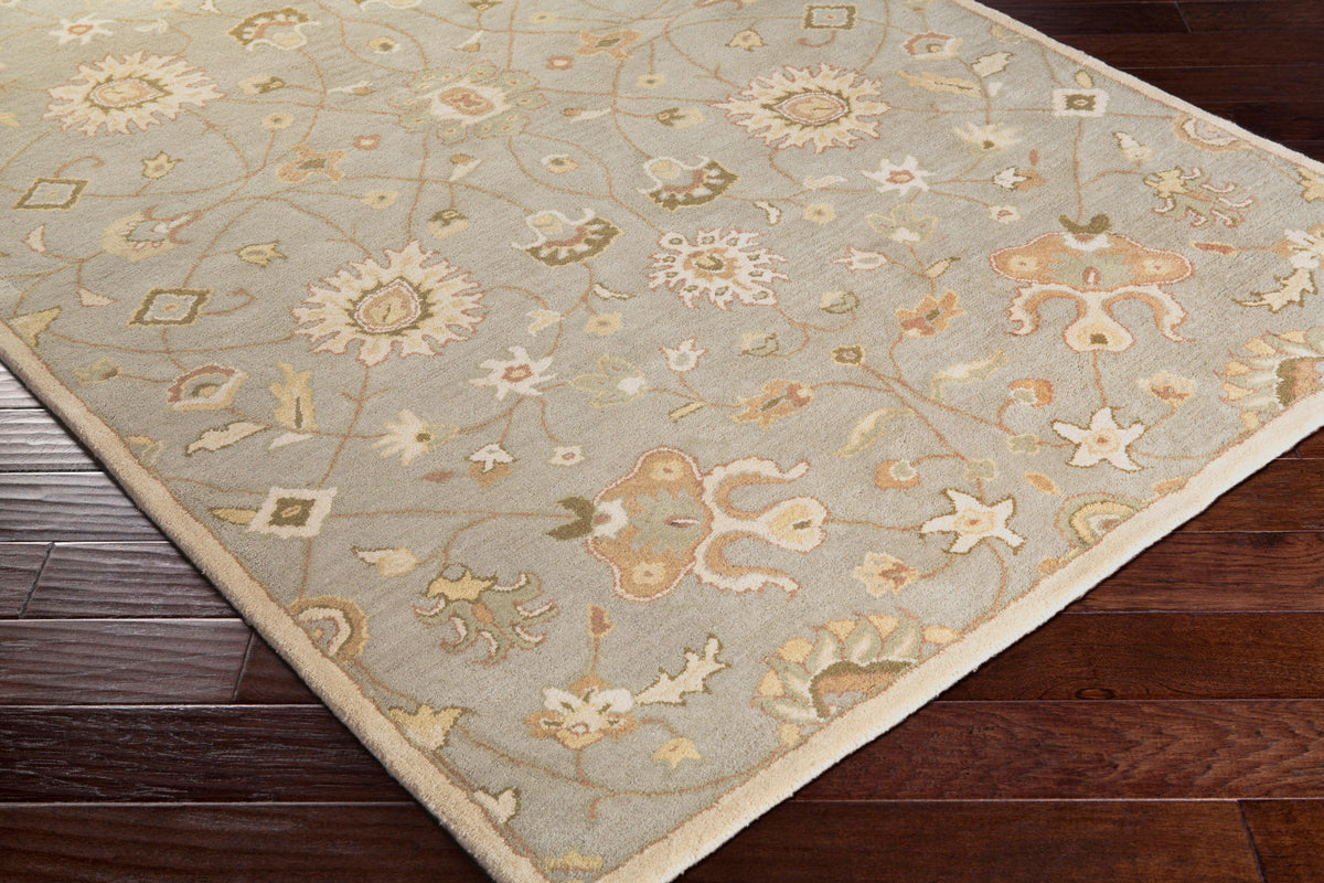 Giardino Stone blue-grey hand-tufted wool rug with a floral pattern on dark wood floors.