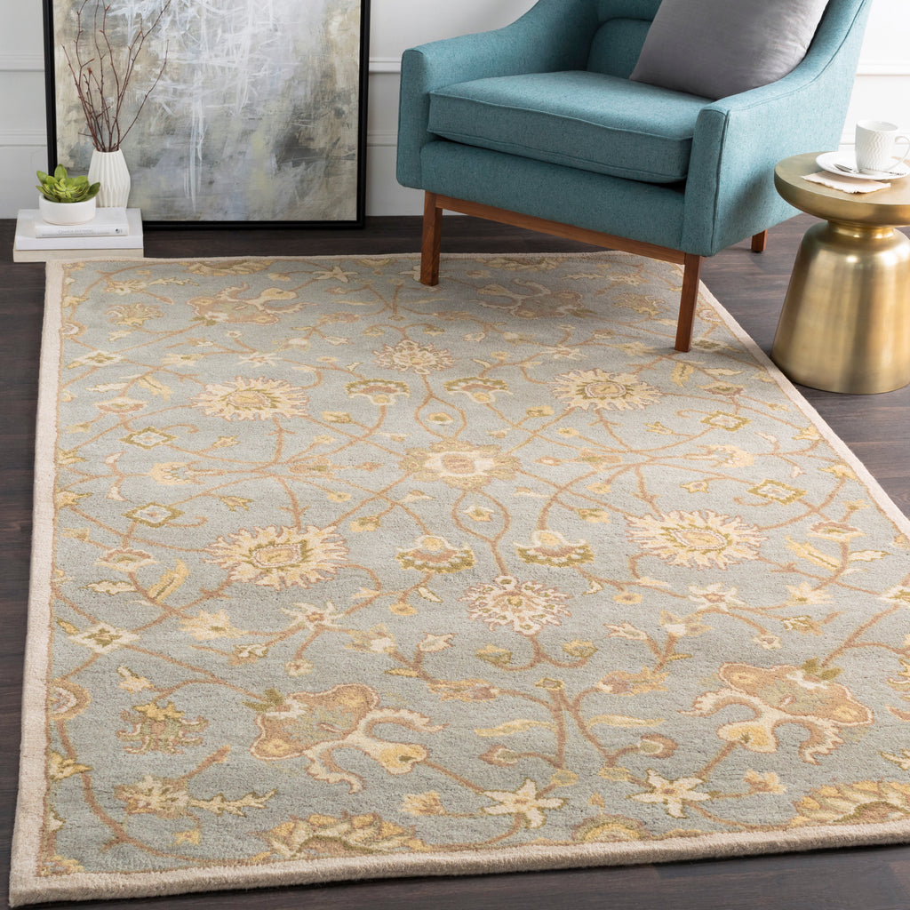 Giardino Stone hand-tufted wool rug with a blue-grey floral pattern in a living room.