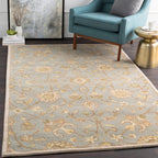 Giardino Stone hand-tufted wool rug with a blue-grey floral pattern in a living room.