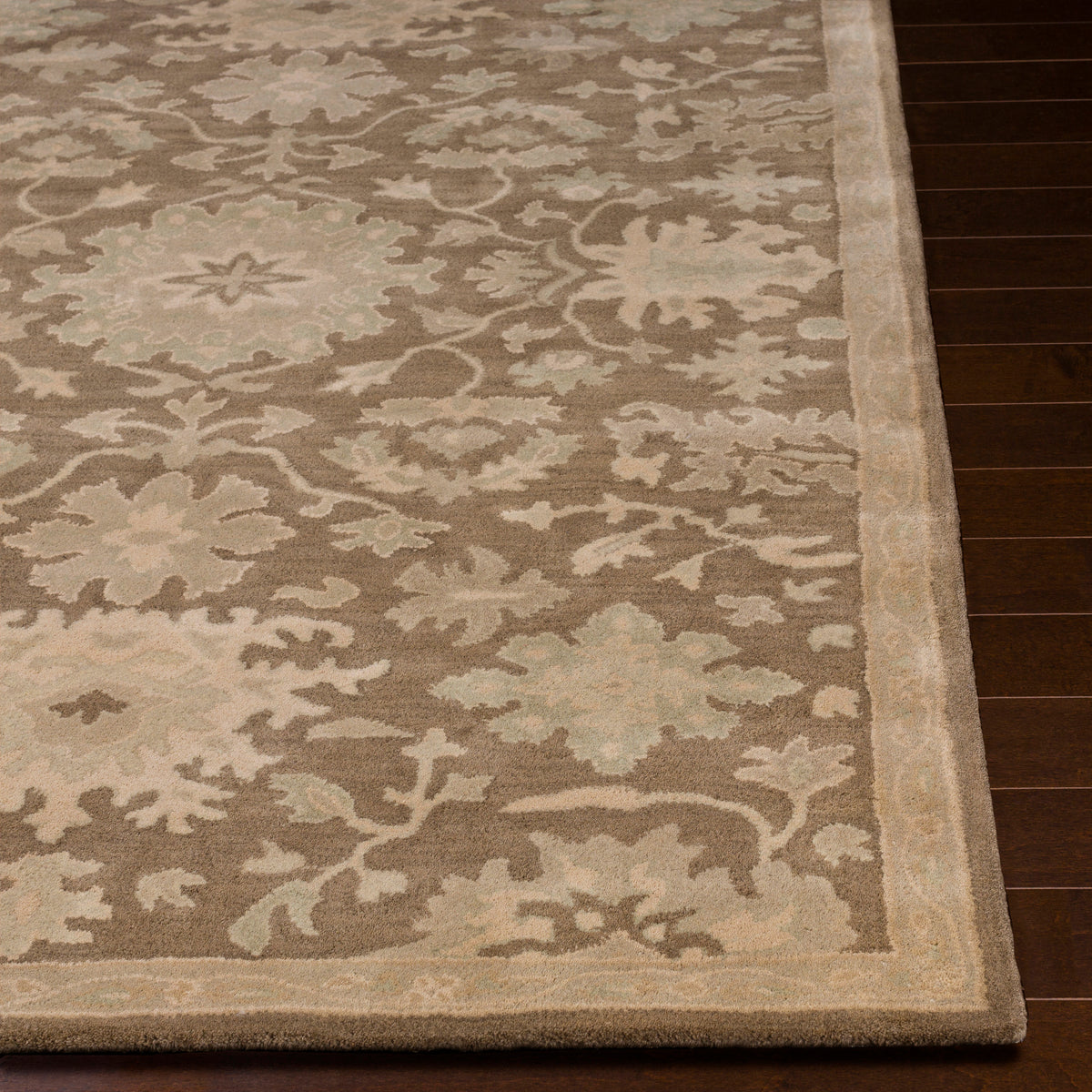 Julian Sand hand-tufted wool rug with a beige floral pattern on dark wood flooring.