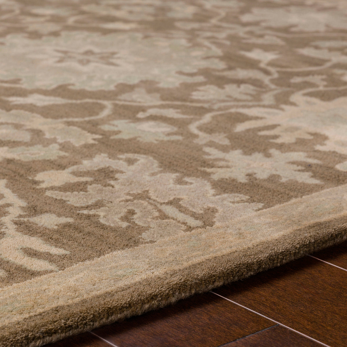 Julian Sand hand-tufted wool rug with a warm beige floral pattern on wood flooring.