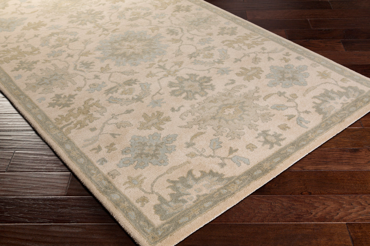 Julian Natural Hand-Tufted wool rug with a beige and sage green floral pattern on dark wood floors.