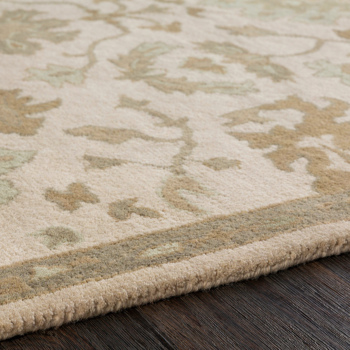 Julian Natural Hand-Tufted Wool Rug with beige and sage green floral patterns on dark wood floor