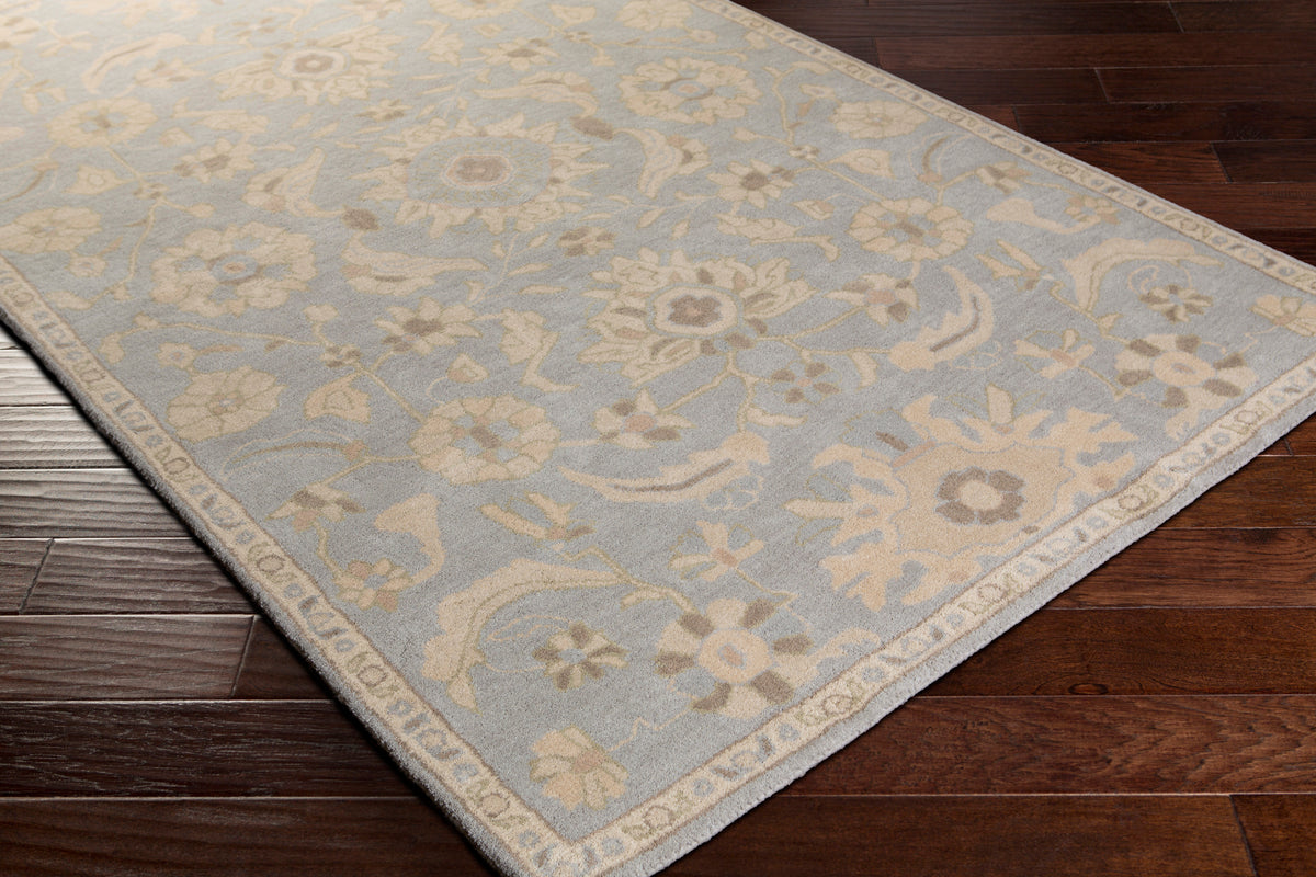 Julian Arctic hand-tufted wool rug with a light blue and beige floral pattern on dark wood floors
