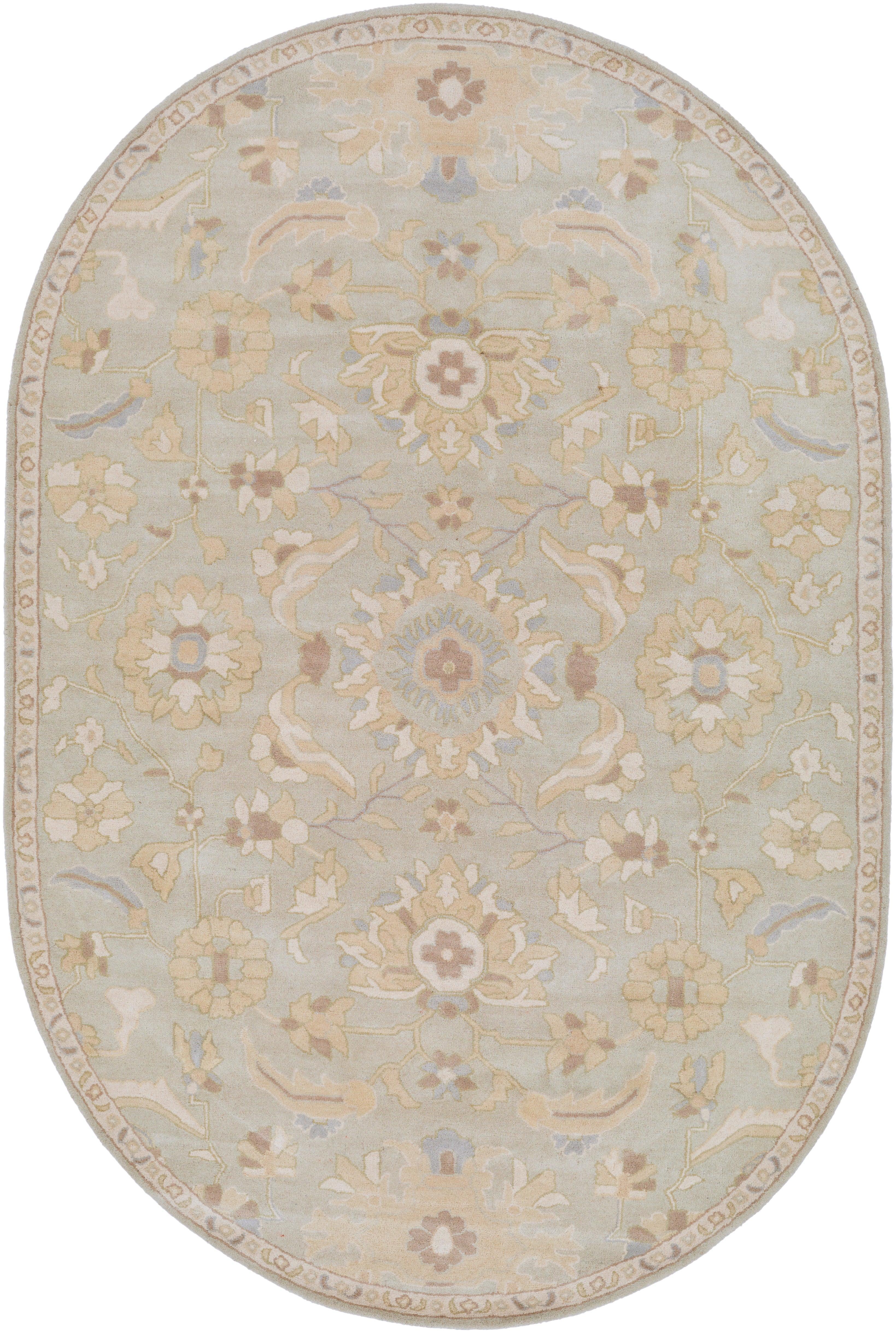 Oval Julian Arctic hand-tufted wool rug with a light blue and beige floral pattern.