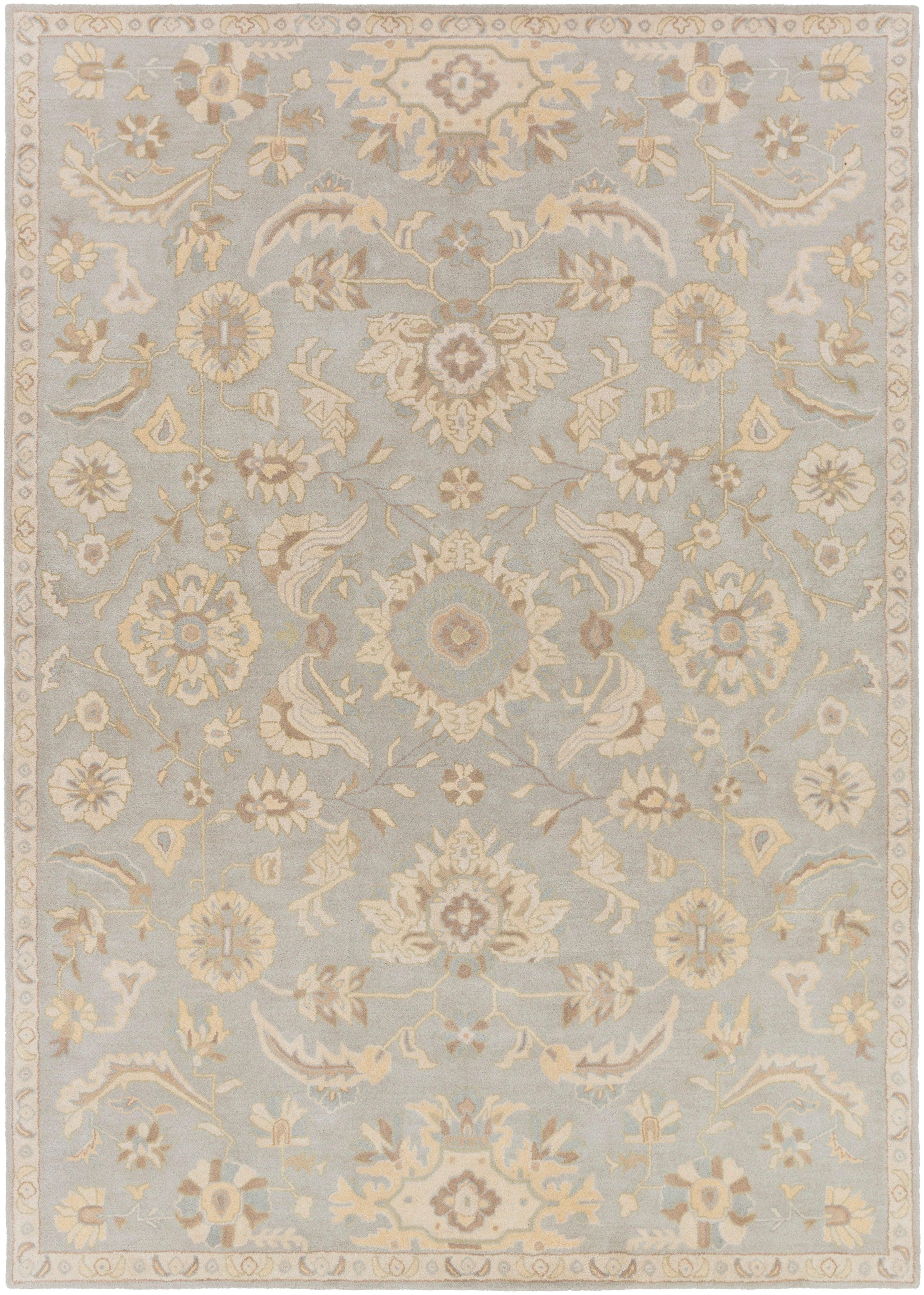 Julian Arctic hand-tufted wool rug featuring a light blue field with beige floral patterns.