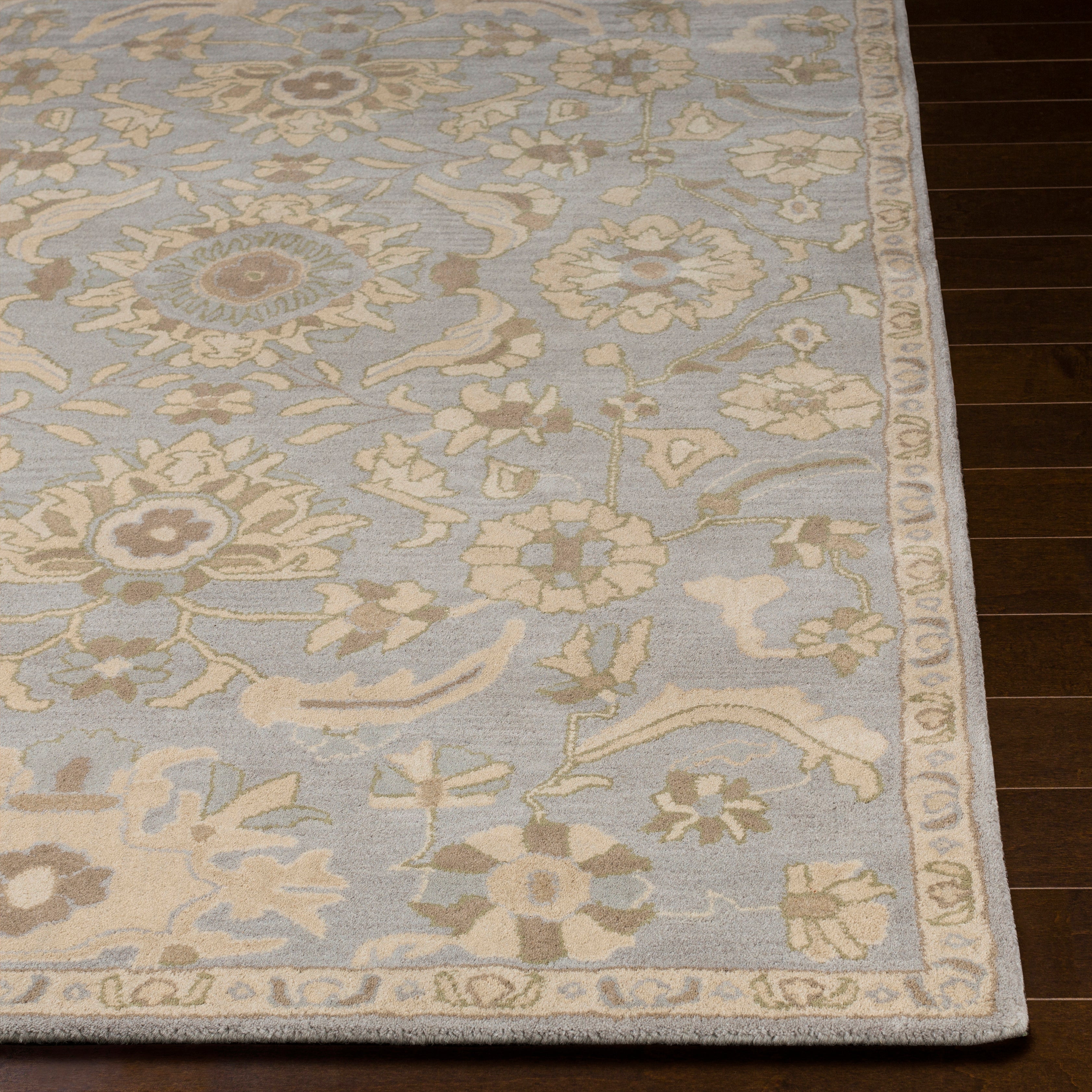 Julian Arctic hand-tufted wool rug with a light blue and beige floral pattern on dark wood flooring.