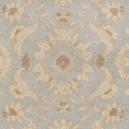 Julian Arctic hand-tufted wool rug with a light blue and beige floral medallion pattern.