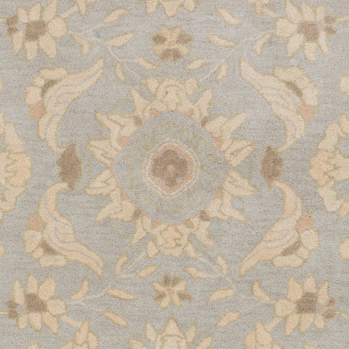Julian Arctic hand-tufted wool rug with a light blue and beige floral medallion pattern.