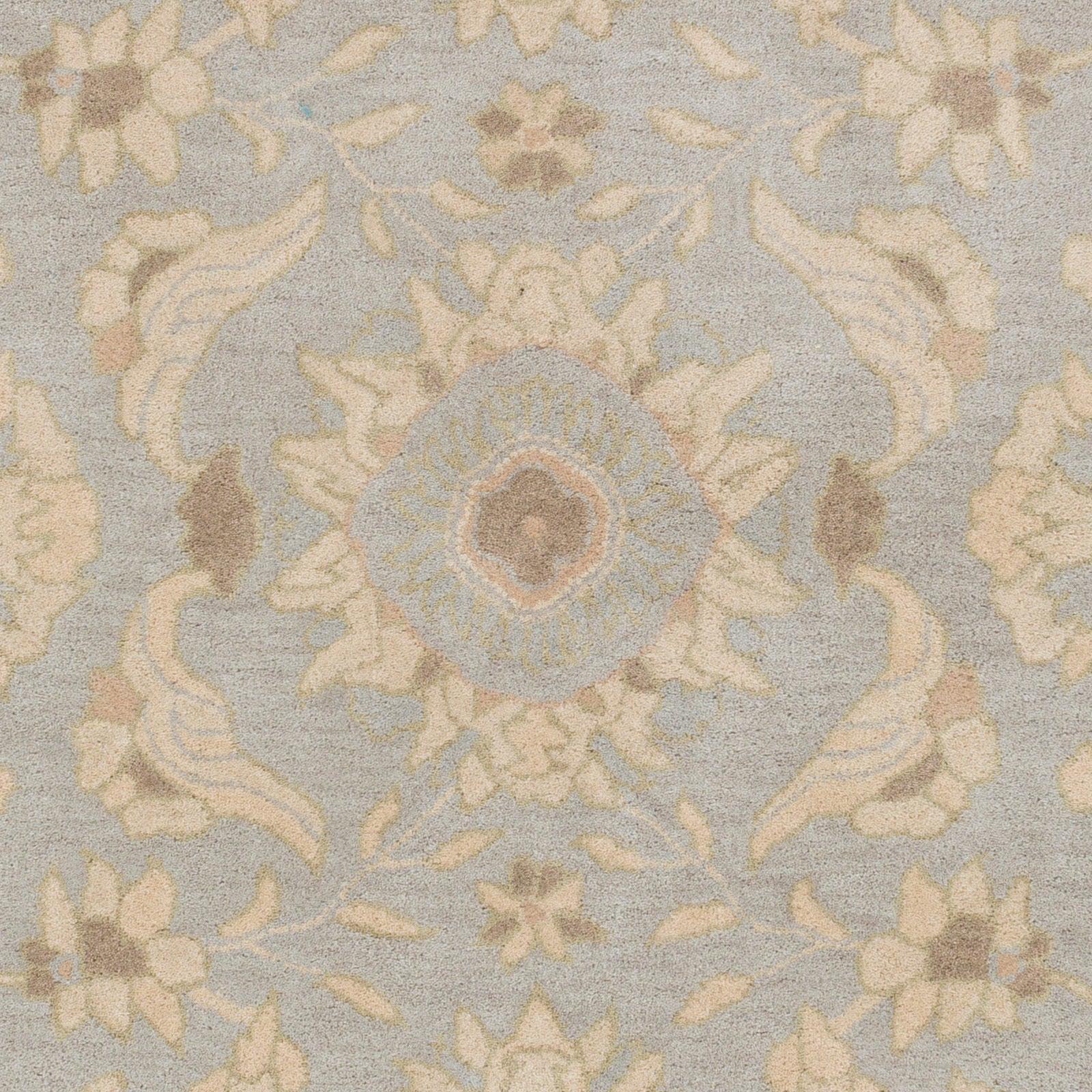 Julian Arctic hand-tufted wool rug with a light blue and beige floral medallion pattern.