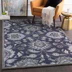 Mediterranean Ocean hand-tufted wool rug with charcoal and denim floral patterns in a living room.
