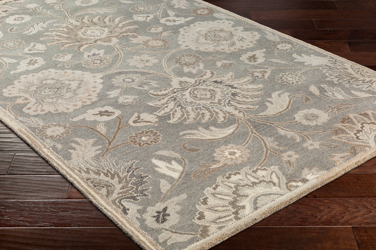 Mediterranean Seal hand-tufted wool rug with grey, taupe, and ivory floral patterns on dark wood floor.