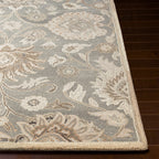 Mediterranean Seal hand-tufted wool rug with grey, taupe, and ivory floral patterns on dark wood floor.